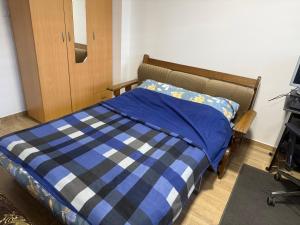 ein Schlafzimmer mit einem Bett mit einer blau-weißen Decke in der Unterkunft Apartman Katarina in Foča