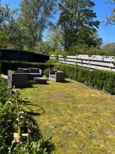 a yard with two couches in front of a fence at De Drentse Rust - Het Atelier in Emmer-Compascuum