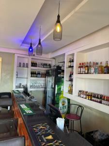 a bar in a restaurant with a counter and chairs at Aape Motel Kamuli in Kamuli
