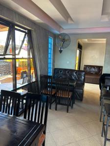 a restaurant with leather furniture and a table and chairs at Aape Motel Kamuli in Kamuli