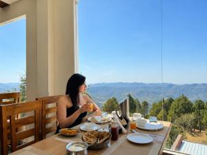 a woman sitting at a table with a drink at Winterline Gold Resort in Lansdowne