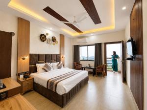 a hotel room with a bed and a woman standing in the window at Winterline Gold Resort in Lansdowne +96 photos