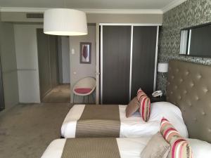 a hotel room with a bed and a chair at Hôtel Le Royal Promenade des Anglais in Nice