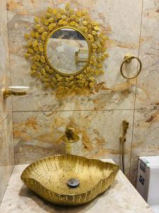 a bathroom with a gold sink and a mirror at Hira Homestay Wayanad, Family-Friendly Stay Near Banasura Dam in Pinangode