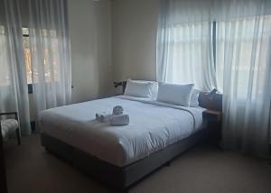 a bedroom with a large white bed with a window at Mercantile Hotel in Sydney