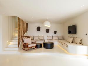 a living room with a couch and a tv at Villa Venti Private Pool Retreat, Mykonos in Agios Ioannis Mykonos