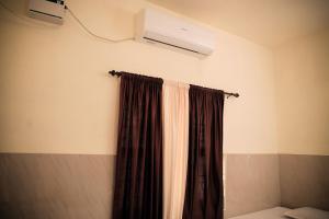 a bedroom with a curtain and a air conditioner at Hotel Jebasakthy in Kanyakumari +6 photos