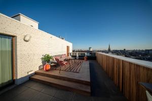 a balcony with chairs and a view of a city at Sunset Penthouse Antwerp in Antwerp