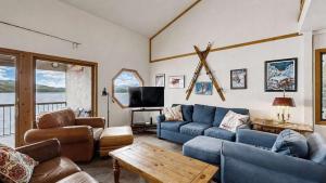 a living room with blue couches and a tv at Lakeside Getaway Beach Access Shared Pool and Grills in McCall