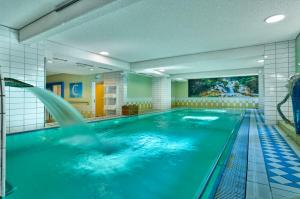 a large swimming pool with a water fountain at Hotel Bayerischer Hof in Bad Füssing