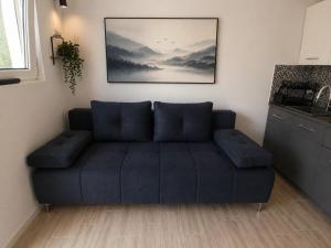 a blue couch in a room with a kitchen at Goga2 in Pirovac
