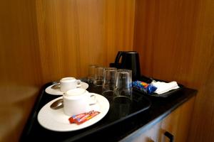 a black counter with two plates and cups on it at Hotel the republic in Zirakpur