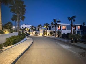 an empty street with palm trees and a house at Pearl Garden in Primošten