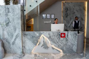 Zwei Personen in einem Büro mit einem roten Kreuz auf einem Tresen in der Unterkunft Alpirious Hotel in Islamabad + 83 Fotos