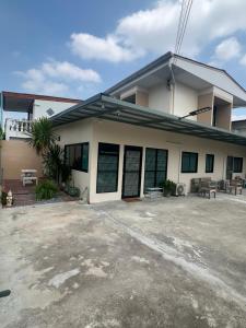 a building with a parking lot in front of it at TUK&TOON House in Sathani Ban Thap Chang