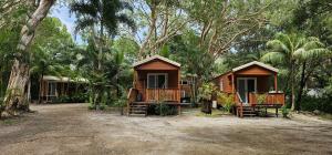 a couple of huts in the middle of trees at Peninsula Caravan Park Cooktown in Cooktown