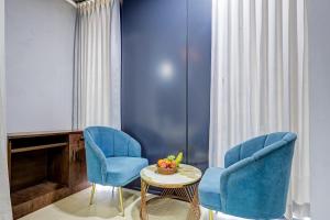 two blue chairs and a table in a room at Hotel Priyaj Newly Built with Luxury Restaurant in Jaipur
