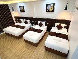 a room with three beds in a room at Khaosok Unseen Resort in Khao Sok National Park