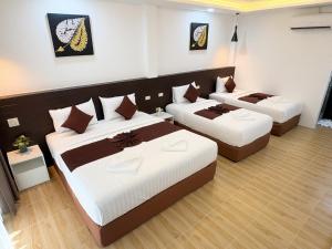 a room with three beds in a room at Khaosok Unseen Resort in Khao Sok National Park