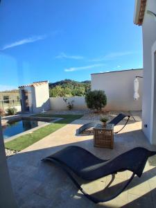 a patio with a hammock and a pool at Maison avec piscine in Cessenon