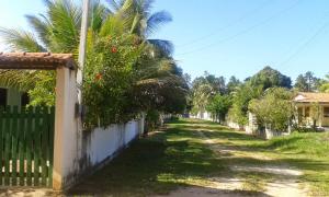 una calle con palmeras y una valla en Casa Verde Maragogi, en Maragogi