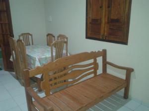 a dining room with a wooden bench and a table at Casa Verde Maragogi in Maragogi