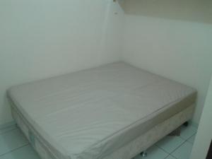 a small bed in a corner of a room at Casa Verde Maragogi in Maragogi