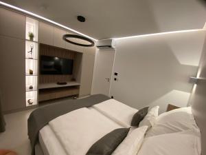 a small room with a bed and a television at Pearl Garden in Primošten +59 photos