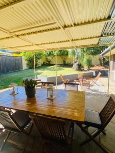 a wooden table and chairs under an umbrella at Mariners Rest in Redland Bay
