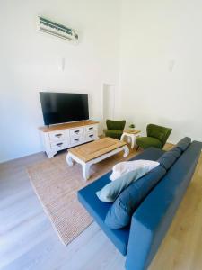 a living room with a blue couch and a tv at Mariners Rest in Redland Bay