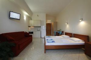 a living room with a bed and a couch at Θέα - View Appartments in Paralia Kimis