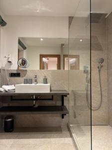 a bathroom with a sink and a shower at Hotel Garni Gästehaus Brand in Bad Wiessee +42 photos