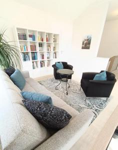 a living room with a couch and a book shelf at Ferienoase Müller in Lichtenhain