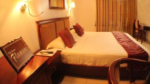 a hotel room with a bed and a desk with a table sidx sidx at Hotel Residence Flamani in Lomé