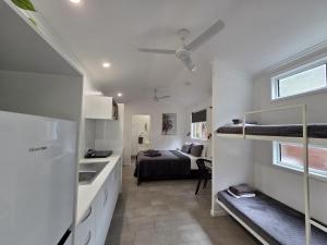 a small room with a bed and a kitchen at Peninsula Caravan Park Cooktown in Cooktown