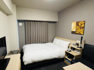 a hotel room with a bed and a desk at Hotel Route-Inn Yanagawa Ekimae in Yanagawa
