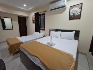 a hotel room with two beds and a air conditioner at Rgn Residency in Singānallūr
