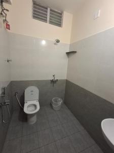 a bathroom with a toilet and a sink at Rgn Residency in Singānallūr +20 photos