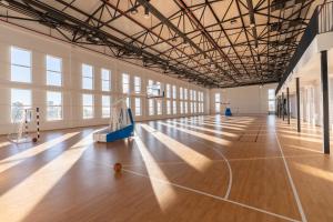 a basketball court in a large room with windows at Academy by Ambassadori in Kachretʼi