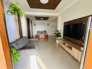 a living room with a large flat screen tv at Beachfront Studio with Cozy and Spacious Balcony in Baling +2 photos