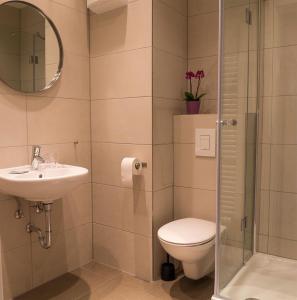 a bathroom with a toilet and a sink and a shower at Hotel Forty Four in Frankfurt