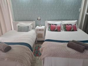 two beds sitting next to each other in a room at Zest in Bloemfontein