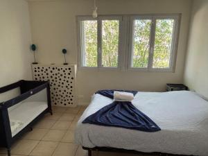 a bedroom with a bed and two windows at Villa Sauna & mer in Sainte-Adresse