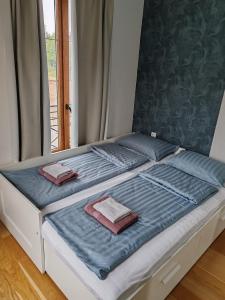 a bed with blue sheets and two pillows on it at Royal Villa - HAWAII in Vrnjačka Banja