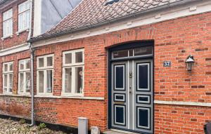 a brick building with a blue door and windows at 4 Bedroom Awesome Home In Ribe in Ribe