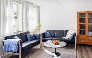 a living room with a blue couch and a table at 4 Bedroom Awesome Home In Ribe in Ribe