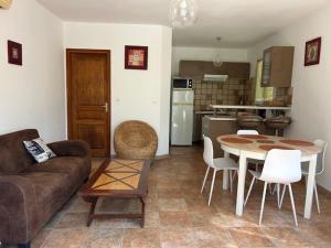 a living room with a couch and a table and a kitchen at Maison Les Pieds dans l eau in Farinole