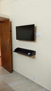 a flat screen tv mounted on a white wall at Rgn Residency in Singānallūr