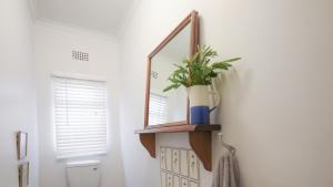 a bathroom with a mirror and a toilet at Rijke Rust, Living the Lagoon Life in Langebaan