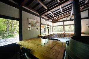 a dining room with a wooden table and chairs at Yamano Hidaya in Matsumoto